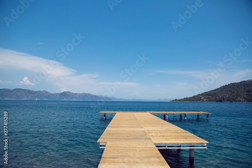 long wooden pier on the sea in Turkey with mountain