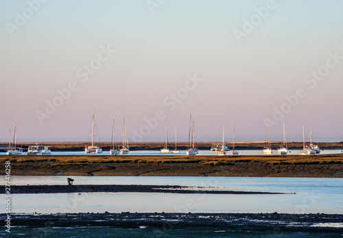 Boats on lagoon at Ria Formosa Natural Park at sunrise, Faro, Algarve, Portugal