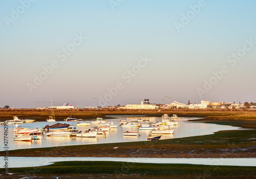 Boats on lagoon at Ria Formosa Natural Park at sunrise, Faro, Algarve, Portugal