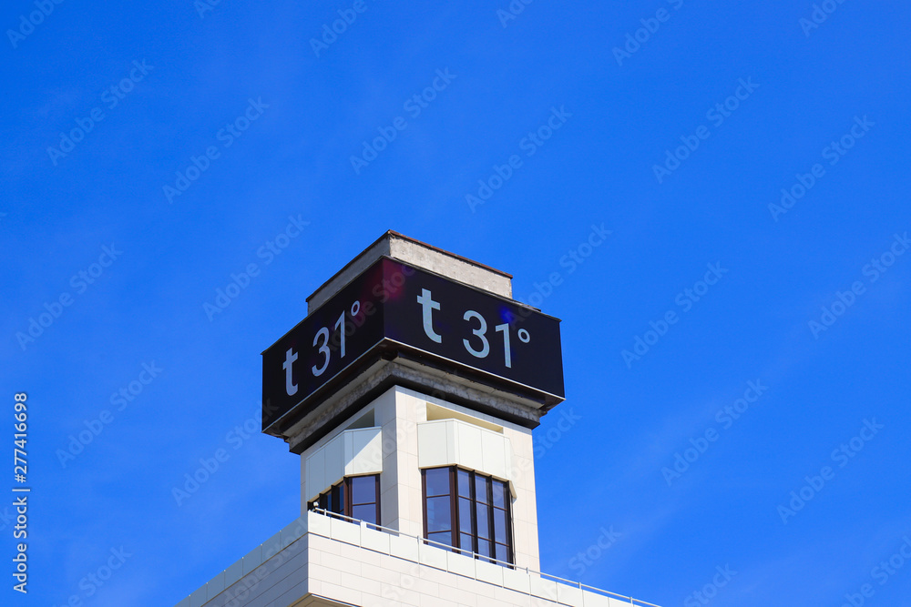 Electronic large thermometer on the building, indicating a high summer air temperature 31 degrees Celsius. Summer hot weather, heat