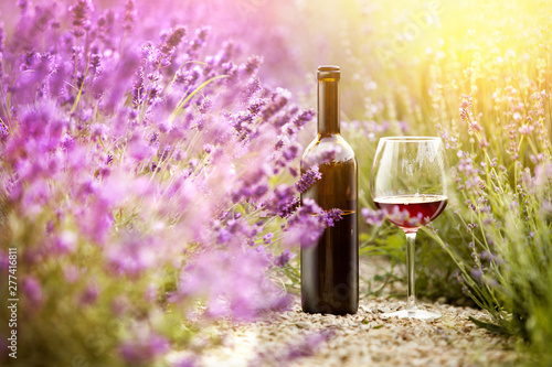 Delicious wine over lavender flowers field. Violet flowers on the background.