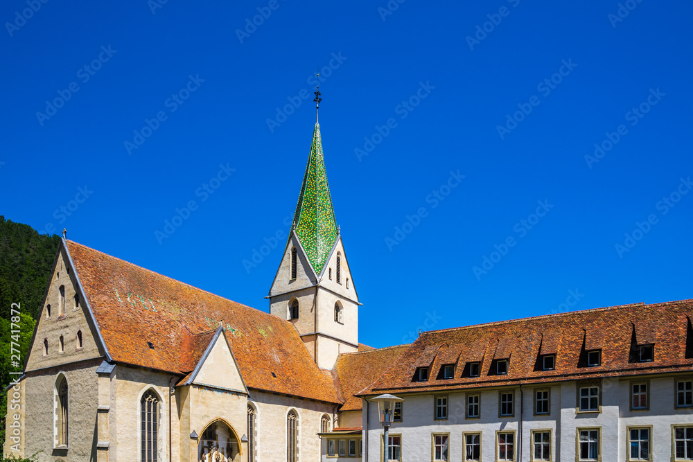 Germany, Ancient historic buildings and beautiful church spire of blaubeuren abbey in old town of blaubeuren town next to popular tourist destination of blautopf source
