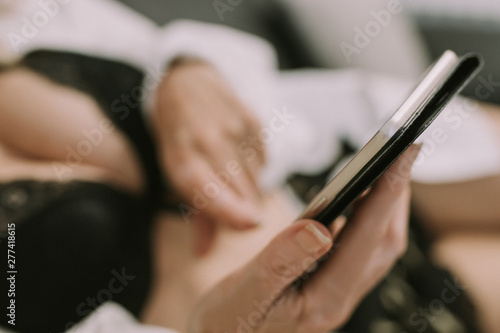 woman at home with cell phone and lingerie