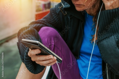 woman with sportswear and mobile phone with headphones in the city