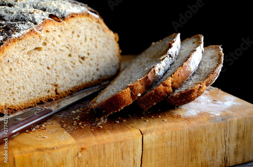 Sliced homemade rustic bread on a wooden table.