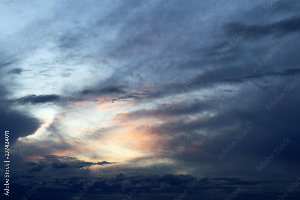 Obraz premium Sunset on colorful sky, sun shining through the dark clouds. Picturesque landscape for background
