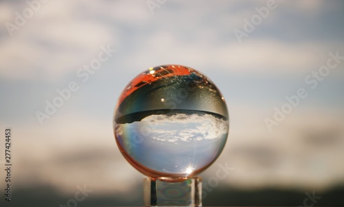 Snow capped mountains in Glacier Bay National Park and Preserve  reflected in crystal ball held by and and