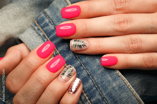 Bright neon manicure on female hands on the background of jeans. Nail design. Beauty hands.