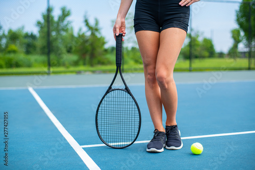 Beautiful woman legs with tennis racket on tennis court © Dmytro Flisak