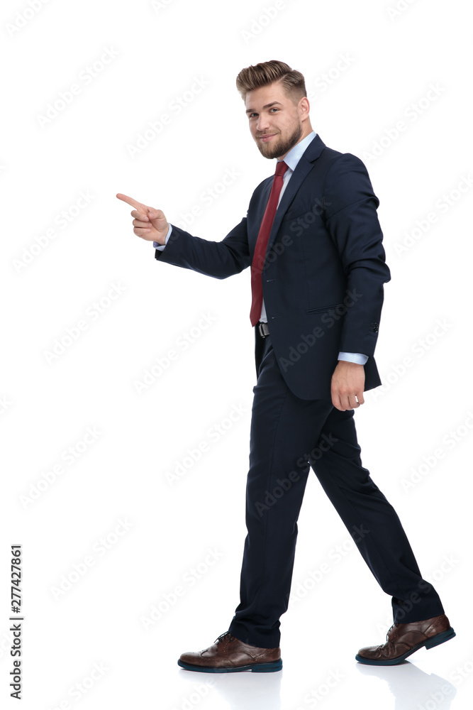 Side view of a handsome businessman stepping and pointing Side view of a handsome businessman stepping and pointing