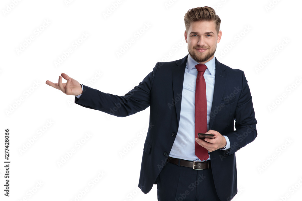 Confident businessman presenting and holding his phone Confident businessman presenting and holding his phone