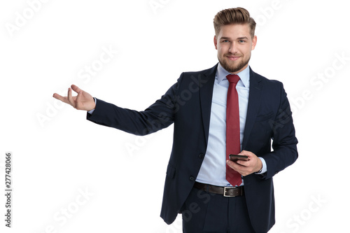 Confident businessman presenting and holding his phone