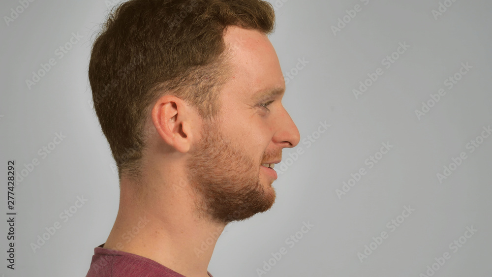 Obraz premium half-face young man with red hair and beard smiling. happy guy with cheerful smile