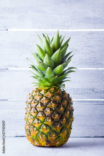 Pineapple on a gray background. Fresh pineapple on a background of boards. Tropical fruit for vegan. Copy space
