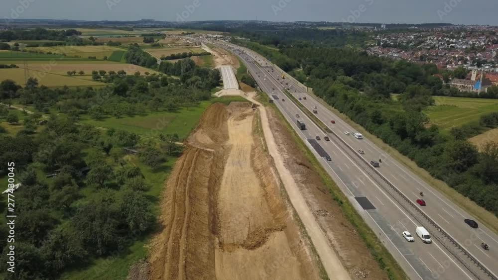 Aerial view of a German Autobahn with construction works for a new railway track next to it. Drone footage taken at Denkendorf near Stuttgart - on a weekend, hence not much truck traffic. Aerial view of a German Autobahn with construction works for a new railway track next to it. Drone footage taken at Denkendorf near Stuttgart - on a weekend, hence not much truck traffic.