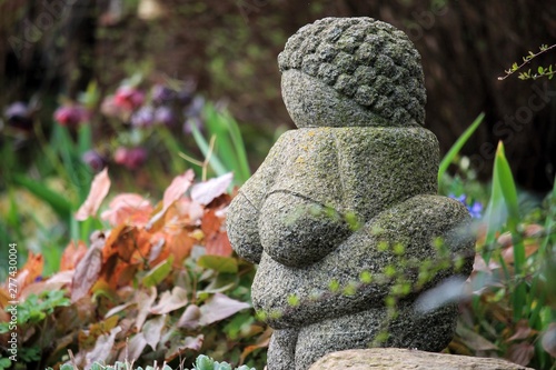 A statue replica of the ancient ”Venus from Willendorf” in a swedish garden in the spring blooming. photo