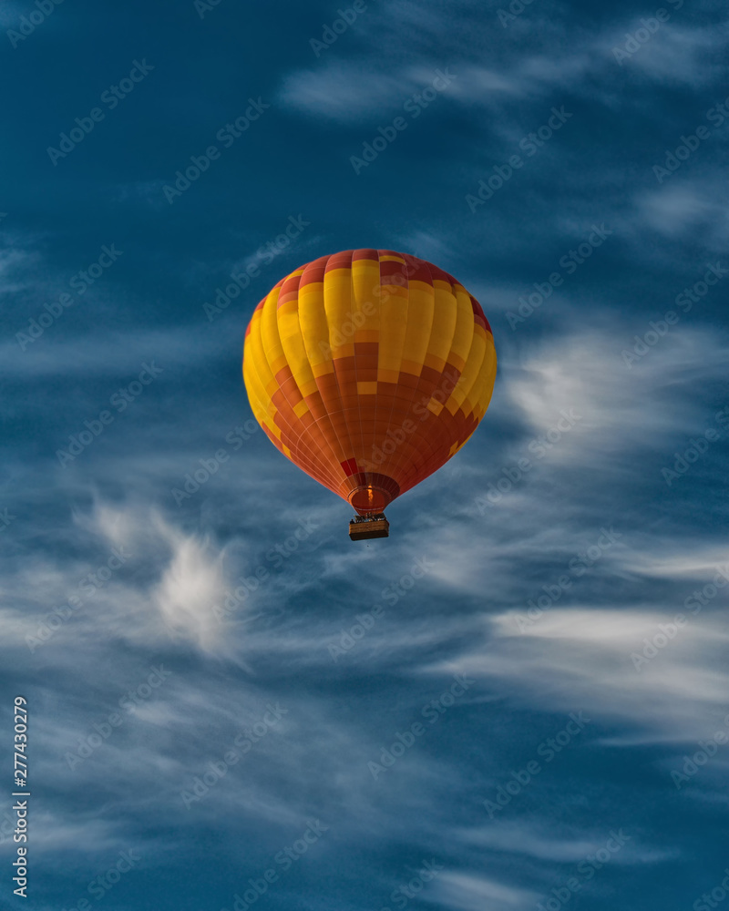 Fototapeta premium Orange air balloon in blue sky. Colorful image for backgrounds, wallpapers. Freedom of movement. Human rights.