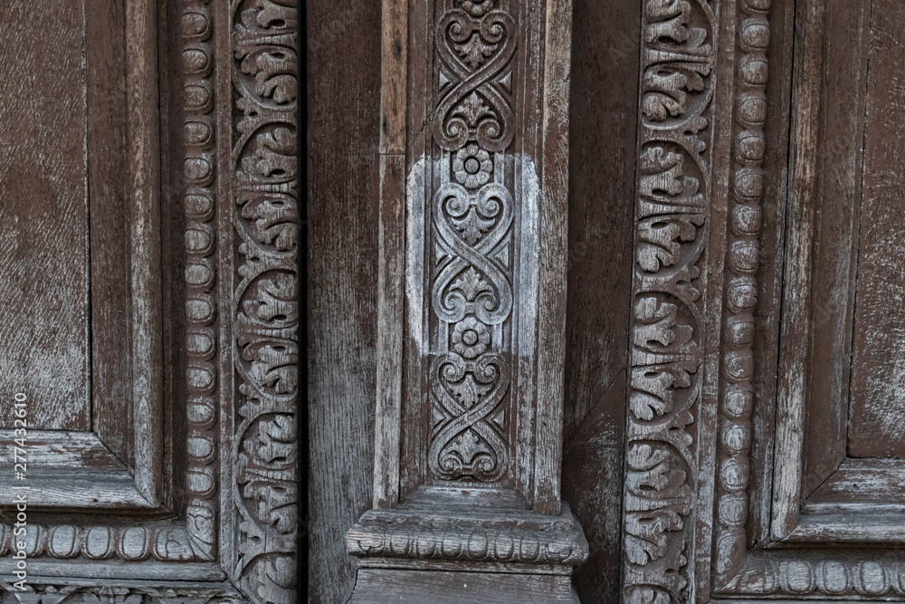Ornamental carving wooden surface closeup of ancient door of Louvre museum in Paris France. Ornate wood texture of old double door closeup. Weathered wooden patterns of doorway panels. Ornamental carving wooden surface closeup of ancient door of Louvre museum in Paris France. Ornate wood texture of old double door closeup. Weathered wooden patterns of doorway panels.