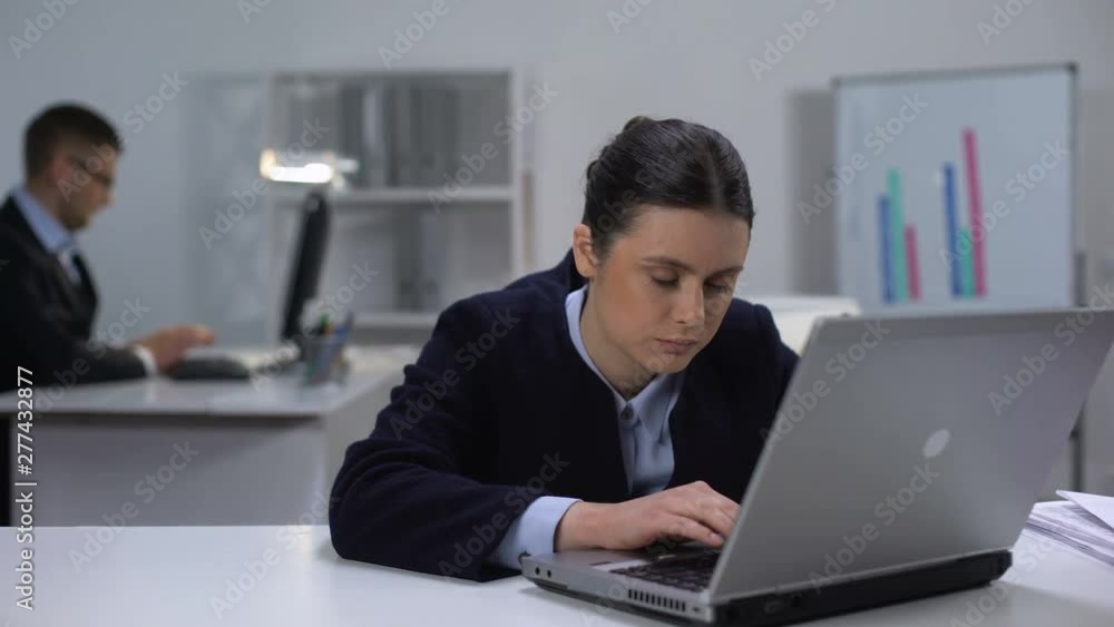 Female manager fighting with sleeping desire at workplace in front of laptop Female manager fighting with sleeping desire at workplace in front of laptop