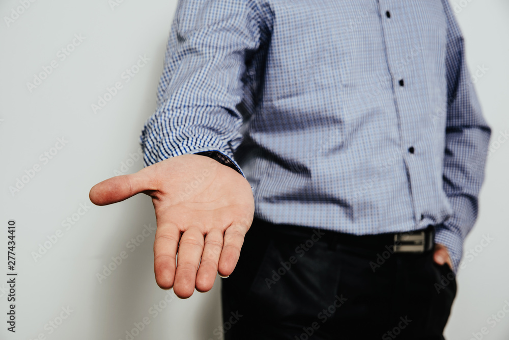 Extending a helping hand. A man dressed in a business shirt stretches out his open hand. The desire to help people, the interlocutor.