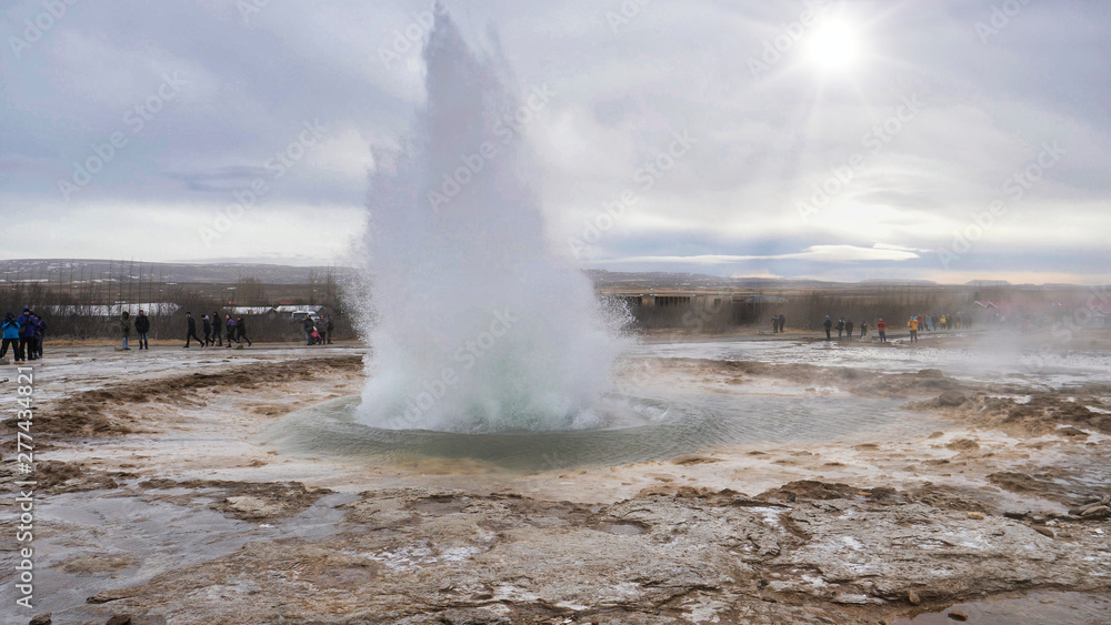 Geyser erupting in Iceland, producing big splash of hot water and steam