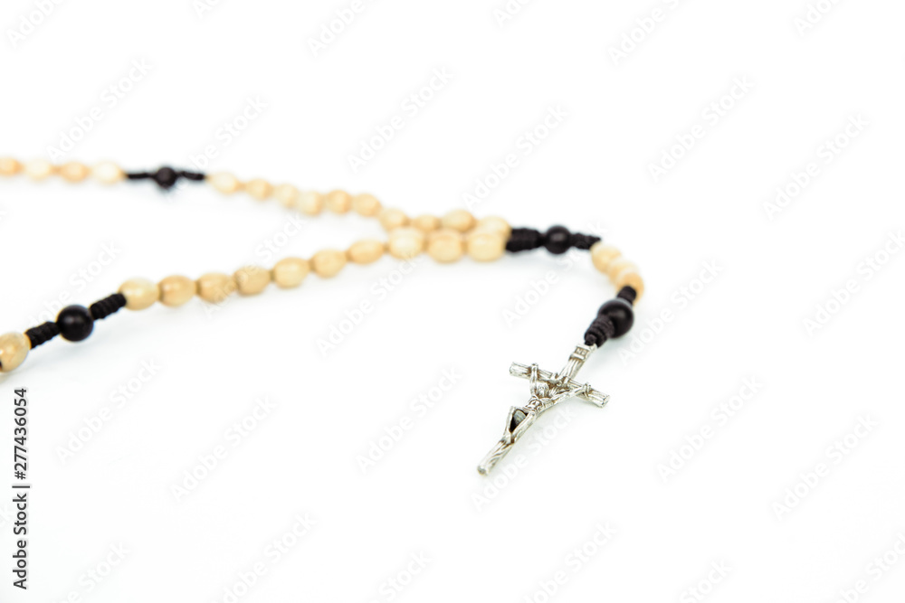 Fototapeta premium Rosary on a white, isolated background. The concept of Christian faith, Catholicism. Pray for grace, faith in God. Problems of the Catholic church, priests' blemishes.