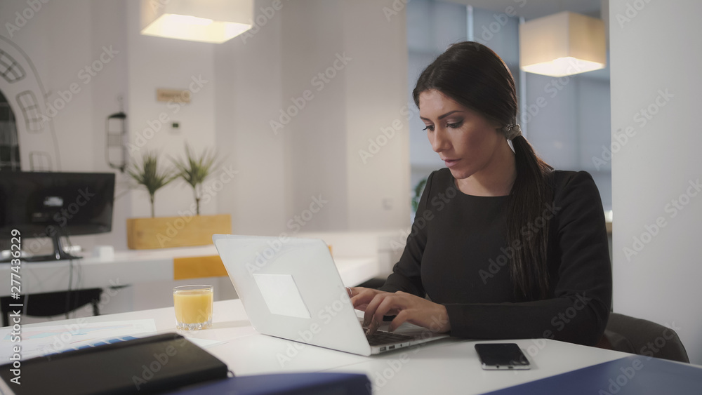 A woman working at the computer and drinking orange juice. UHD A woman working at the computer and drinking orange juice. UHD
