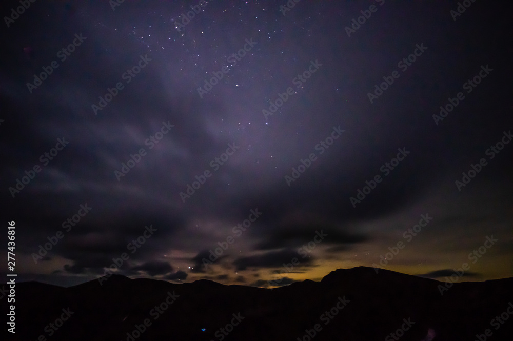 Starry sky at night over the mountains in the Carpathians