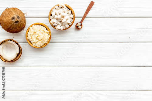 Body treatment with coconut cosmetic on white wooden background top view copyspace