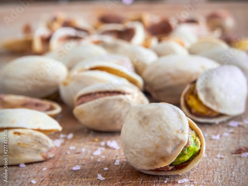 Pistachioes on the wooden and blurry background salty close up photo