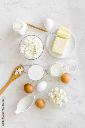 Fresh dairy products for breakfast with milk  cottage  eggs  butter  yougurt on white marble background top view mock up