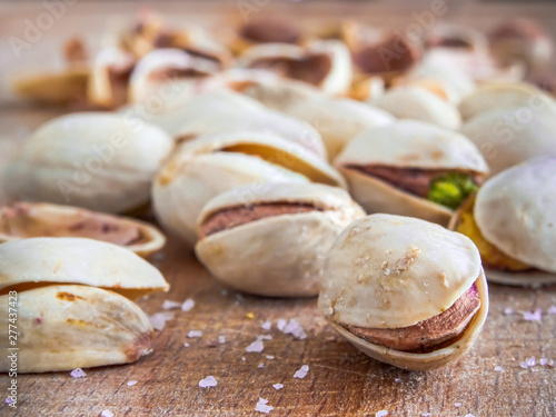 Pistachioes on the wooden and blurry background salty close up photo