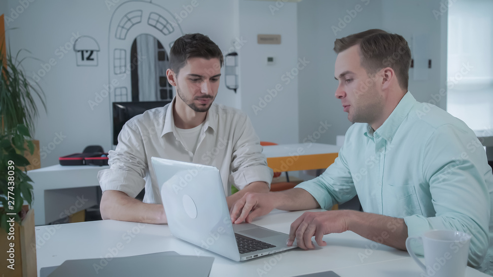 Young handsome caucasian male sitting at the workplace. Businessman working at creative office. Young handsome caucasian male sitting at the workplace. Businessman working at creative office.