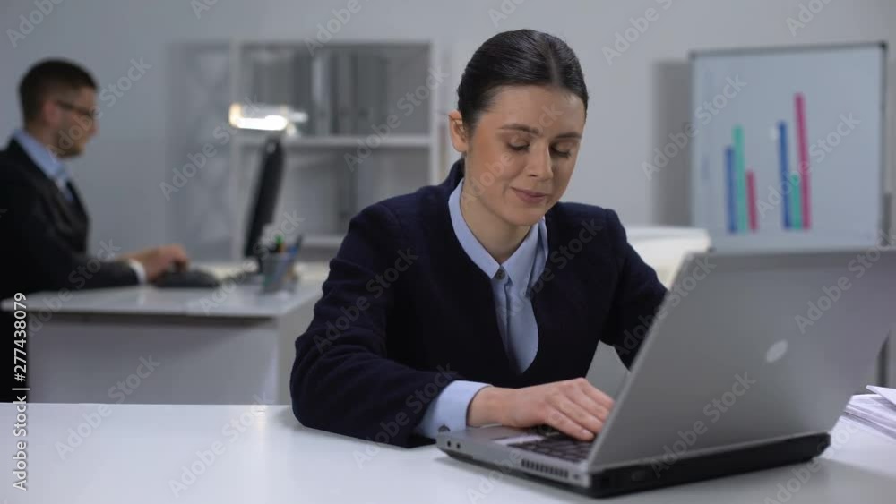 Cute female manager working on laptop, looking at male colleague, secret love