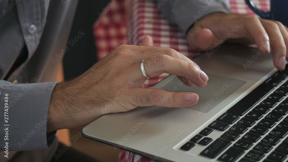 close up details man typing on laptop. Male hands entering data on keyboard