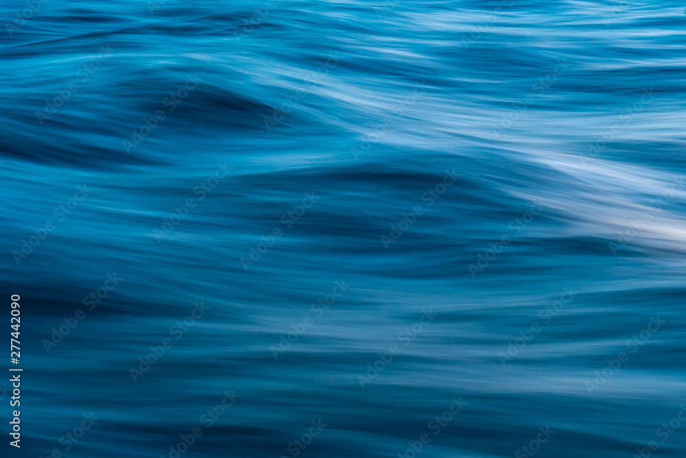 Gentle soothing silky flowing natural ocean water movement. Abstract background motion blur. Serene and peaceful deep blue sea in nature. Gentle soothing silky flowing natural ocean water movement. Abstract background motion blur. Serene and peaceful deep blue sea in nature.
