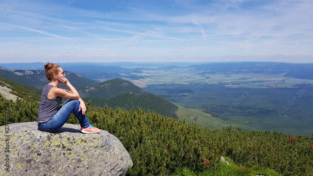 Naklejka premium Young woman enjoying picturesque view of the mountains, freedom and relaxation concept