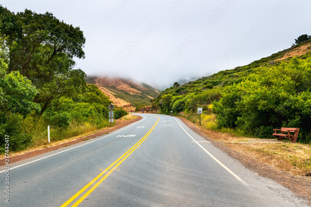 Paved road with a 35 mph speed limit going through Marin Headlands; cloudy and foggy day; Marin County, North San Francisco bay area, California Paved road with a 35 mph speed limit going through Marin Headlands; cloudy and foggy day; Marin County, North San Francisco bay area, California