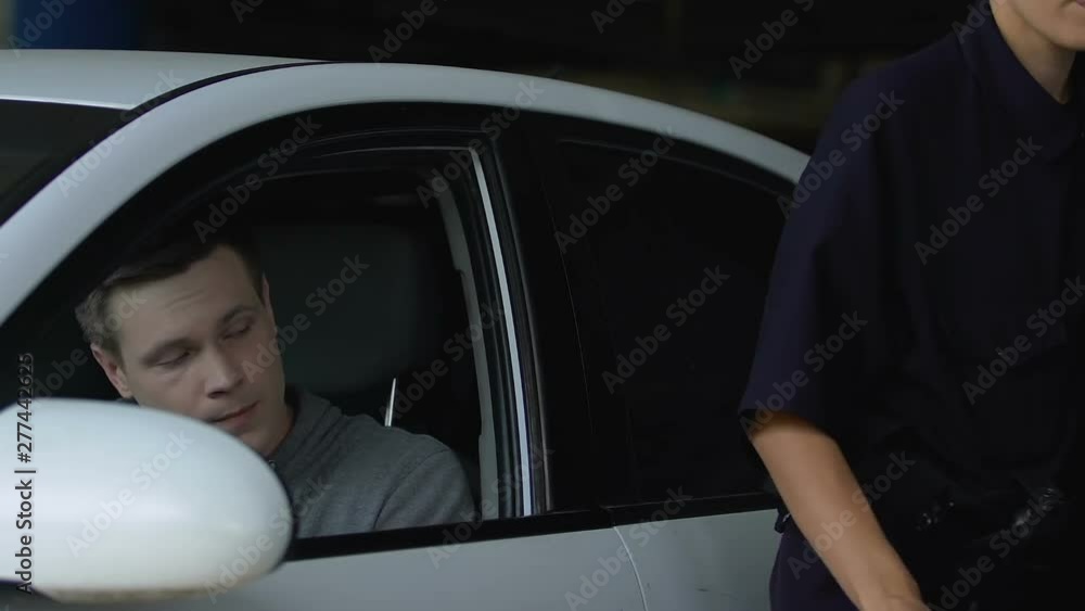 Patrolwoman writing parking ticket to driver, fine for traffic rules violation Patrolwoman writing parking ticket to driver, fine for traffic rules violation
