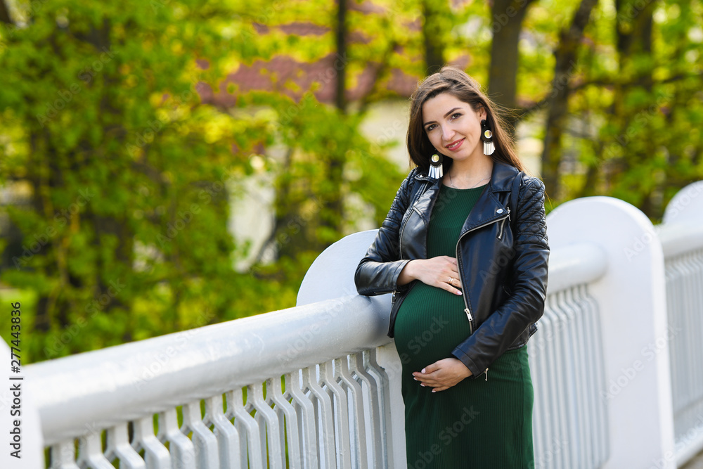 pregnant girl on the bridge. Portrait of a young happy pregnant woman on a white bridge. Rest and enjoy nature - obrazy, fototapety, plakaty 