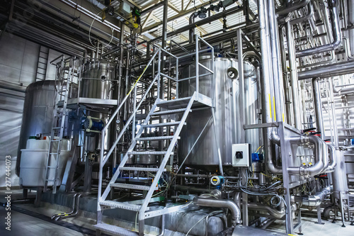 Stainless steel brewing equipment, iron reservoirs or tanks and pipes in modern beer factory. Brewery production concept, industrial background