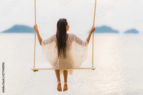 Portrait beautiful young asian woman sitting on the swing around beach sea ocean for relax