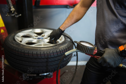 Man using the manometer to inflate a new tire in the garage