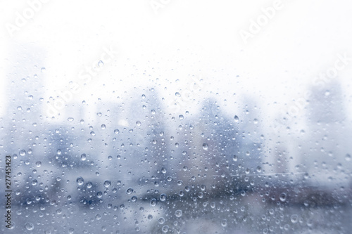 Abstract blurred of water dropped onto window in rainy season in Bangkok.