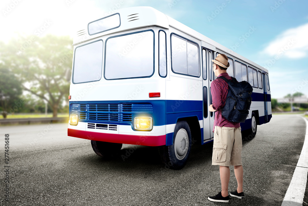 Rear view of asian man in hat with backpack standing and waiting a bus on the road