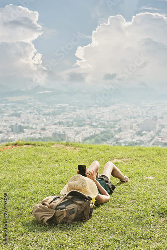 woman lie on grassland and using cellphone