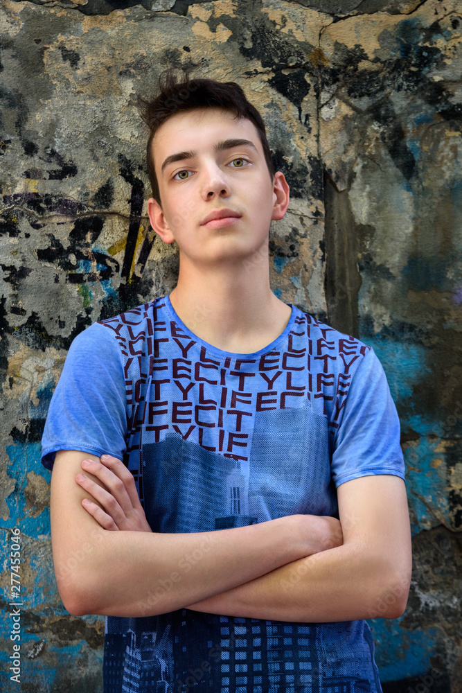 Portrait of teenage boy near the wall on the street Portrait of teenage boy near the wall on the street