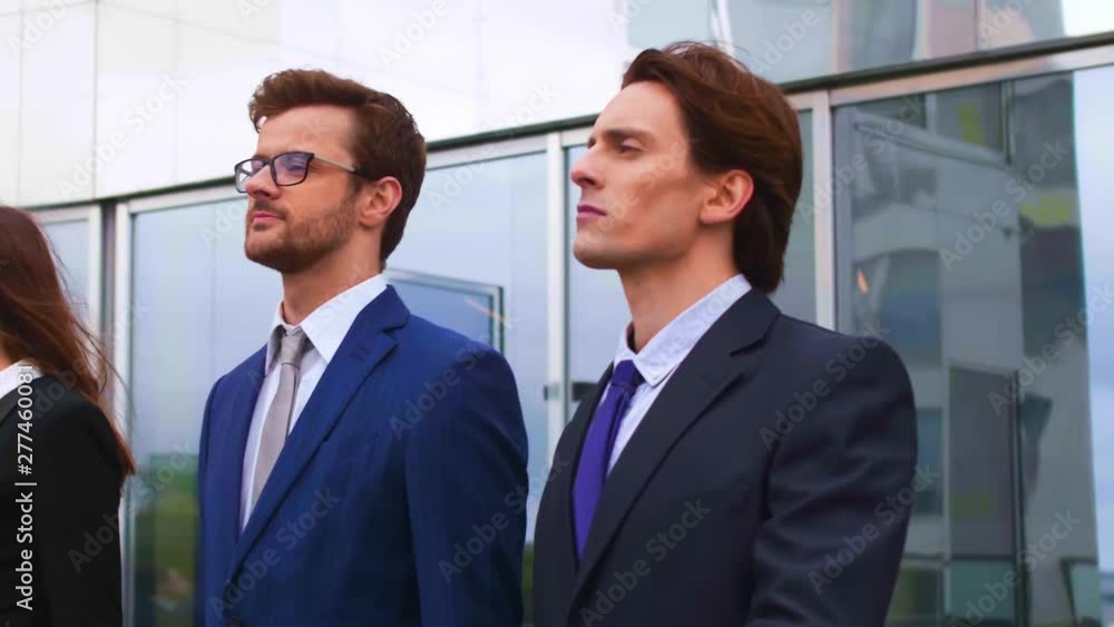 Confident businesspersons talking in front of modern office building. Businessmen and businesswoman have business conversation. Banking, professional job and financial market. Confident businesspersons talking in front of modern office building. Businessmen and businesswoman have business conversation. Banking, professional job and financial market.