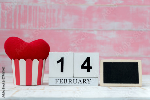 Wooden Calendar On February 14, two red hearts were placed side by side and the background is pink. Valentine day.