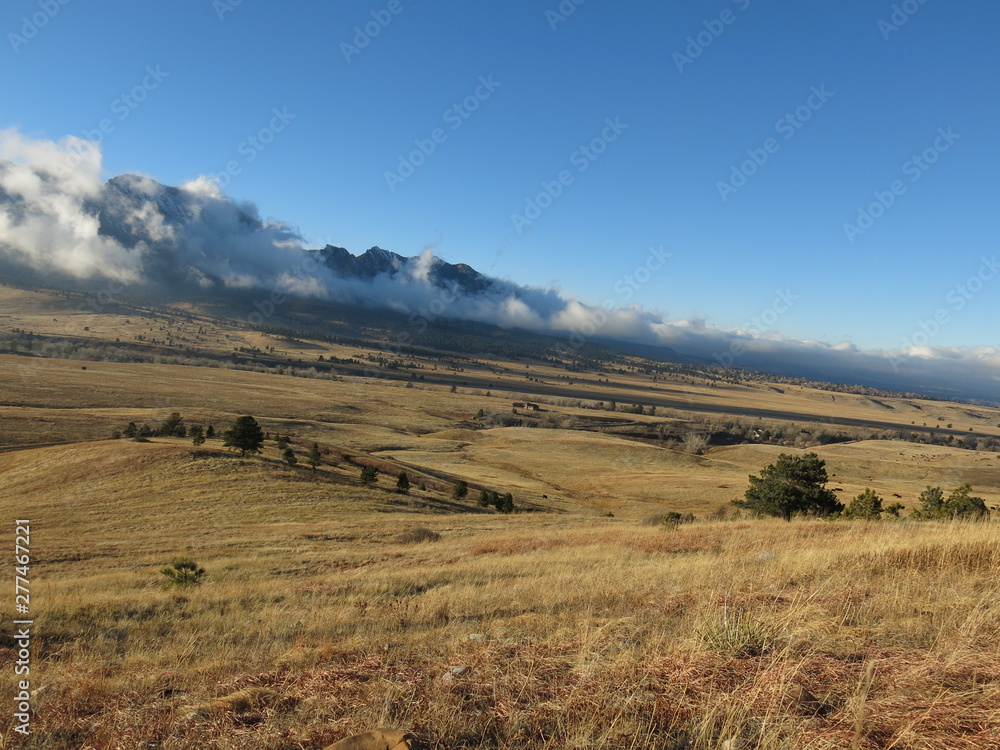 Obraz premium Clouds rolling off mountains Colorado sunset